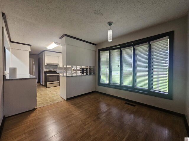 5182 State Route 58 E, Clinton, KY 42031 - unfurnished dining area with wood finished floors, baseboards, and a textured ceiling