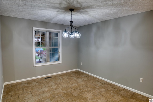 5904 Moors Camp Hwy, Gilbertsville, KY 42044 - empty room with a textured ceiling, baseboards, stone finish flooring, and a chandelier