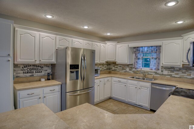 5904 Moors Camp Hwy, Gilbertsville, KY 42044 - kitchen with appliances with stainless steel finishes, a sink, a textured ceiling, decorative backsplash, and white cabinets