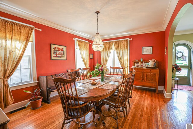 1931 Jefferson St, Paducah, KY 42001 - dining room featuring arched walkways, a chandelier, hardwood / wood-style floors, crown molding, and baseboards