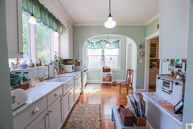 1931 Jefferson St, Paducah, KY 42001 - kitchen with dishwasher, a sink, arched walkways, tasteful backsplash, and light wood-style floors