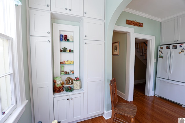 1931 Jefferson St, Paducah, KY 42001 - kitchen with freestanding refrigerator, arched walkways, light wood finished floors, ornamental molding, and white cabinetry