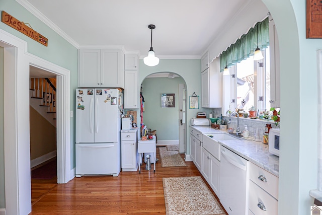 1931 Jefferson St, Paducah, KY 42001 - kitchen with white appliances, arched walkways, a sink, light wood-style floors, and decorative light fixtures