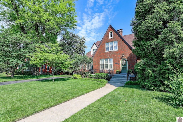 1931 Jefferson St, Paducah, KY 42001 - tudor home with a front lawn, brick siding, and a chimney
