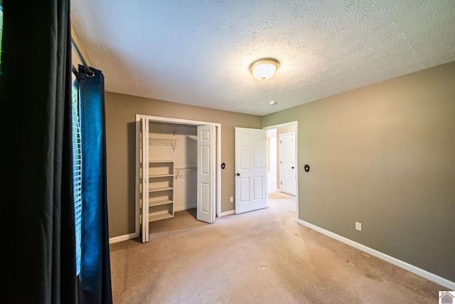 200 Lions Den Ln, Paducah, KY 42003 - unfurnished bedroom with baseboards, light carpet, a closet, and a textured ceiling