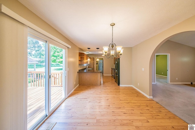 200 Lions Den Ln, Paducah, KY 42003 - unfurnished dining area with arched walkways, light wood-style floors, a sink, and a chandelier