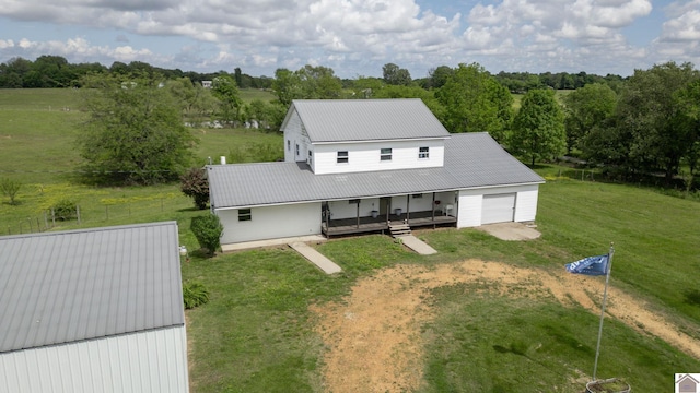 711 Rocky Rd, Fancy Farm, KY 42039 - view of front of house featuring driveway, a front yard, an attached garage, metal roof, and covered porch