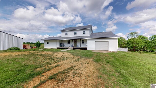 711 Rocky Rd, Fancy Farm, KY 42039 - back of house featuring a porch, a lawn, metal roof, an attached garage, and driveway