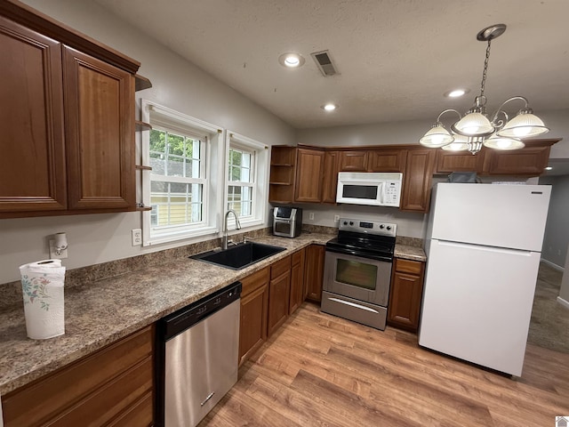 kitchen featuring stainless steel appliances, a sink, recessed lighting, light wood-style flooring, and open shelves