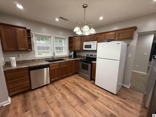 kitchen featuring appliances with stainless steel finishes, open shelves, a sink, a chandelier, and light wood-type flooring