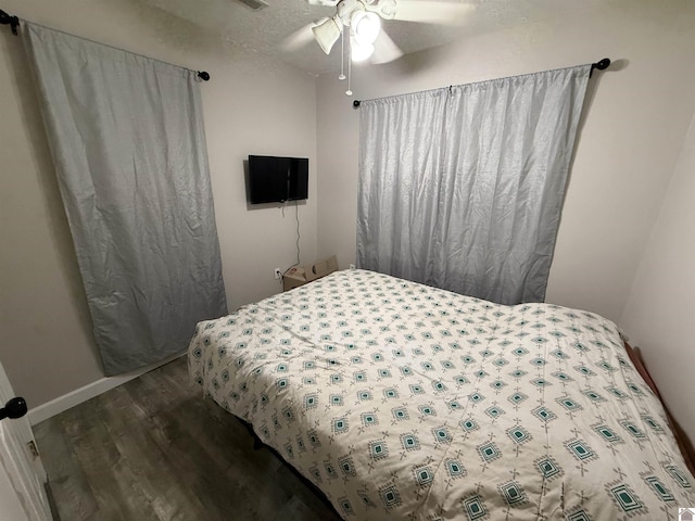 bedroom with dark wood-style flooring, ceiling fan, and baseboards