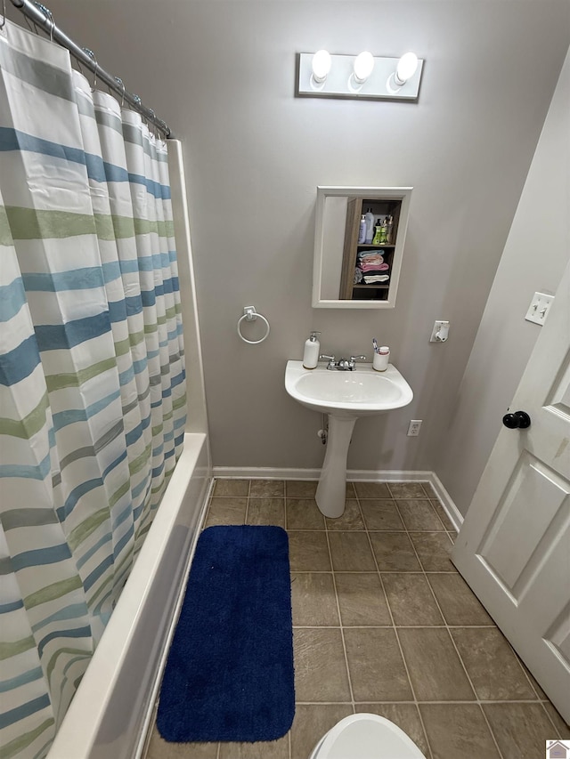 bathroom with tile patterned floors, baseboards, and shower / bath combination with curtain