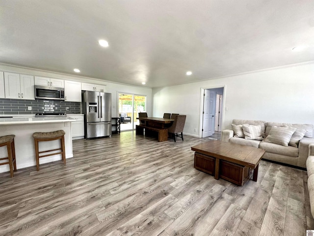 566 Golden Meadow Ln, Ledbetter, KY 42058 - living area featuring light wood finished floors, recessed lighting, crown molding, and baseboards