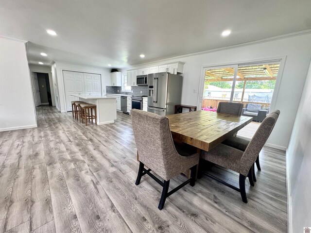 566 Golden Meadow Ln, Ledbetter, KY 42058 - dining room featuring ornamental molding, light wood-style flooring, recessed lighting, and baseboards