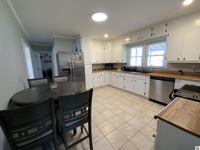 3827 Howle, Paducah, KY 42003 - kitchen with appliances with stainless steel finishes, a sink, light tile patterned flooring, ornamental molding, and white cabinetry