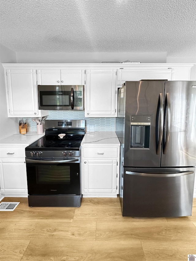 206 Metcalf Ln, Almo, KY 42020 - kitchen with appliances with stainless steel finishes, white cabinetry, light countertops, light wood-style floors, and a textured ceiling