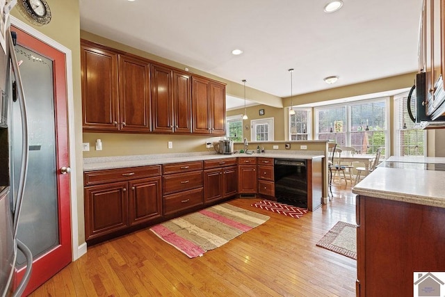 2007 Atkins Way, Murray, KY 42071 - kitchen featuring stainless steel appliances, light wood-style floors, a peninsula, light countertops, and decorative light fixtures
