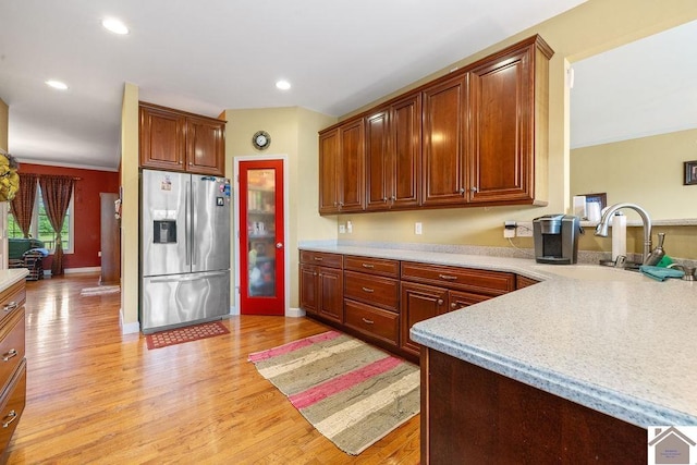 2007 Atkins Way, Murray, KY 42071 - kitchen with stainless steel fridge with ice dispenser, light wood-type flooring, light countertops, a sink, and a peninsula