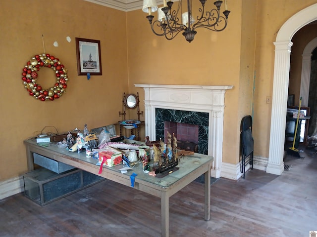 703 Fulton St, Hickman, KY 42050 - living area featuring arched walkways, a fireplace, wood finished floors, a chandelier, and ornate columns