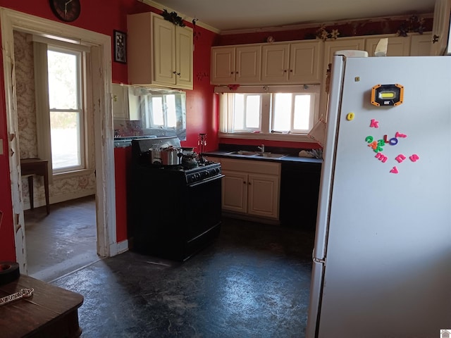 703 Fulton St, Hickman, KY 42050 - kitchen with freestanding refrigerator, black range with gas cooktop, a sink, ornamental molding, and white cabinets
