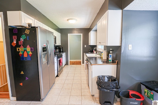 1124 Friedman Ln, Paducah, KY 42001 - kitchen featuring stainless steel appliances, a sink, white cabinetry, a textured ceiling, and light tile patterned floors