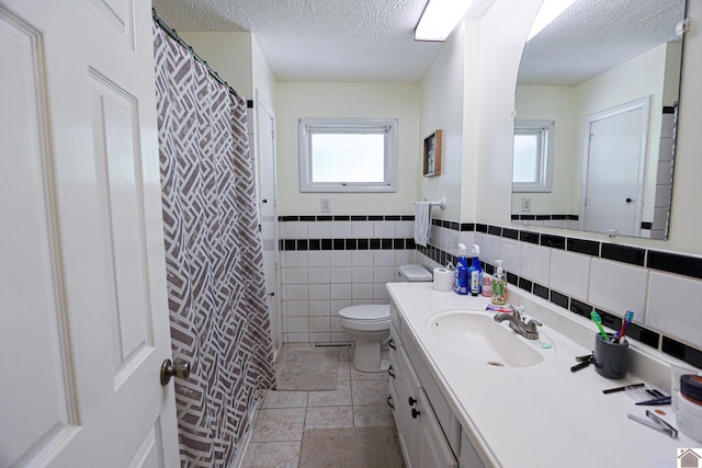 1124 Friedman Ln, Paducah, KY 42001 - full bathroom featuring a textured ceiling, toilet, plenty of natural light, vanity, and tile walls