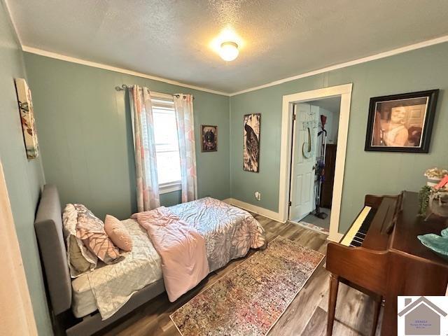 3944 Old Mayfield Rd, Paducah, KY 42003 - bedroom with ornamental molding, wood finished floors, a textured ceiling, baseboards, and ensuite bathroom