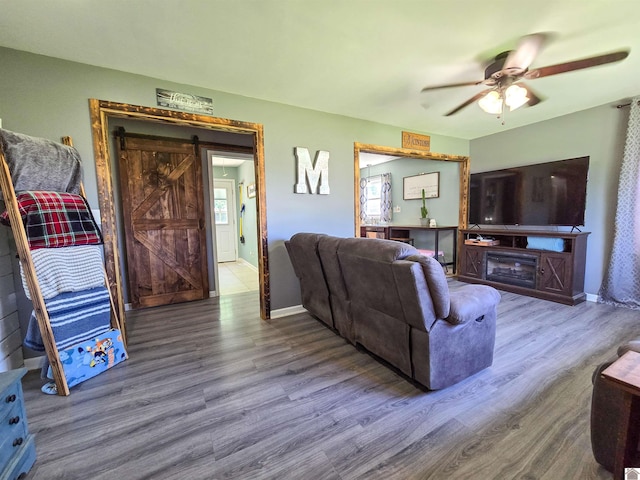 2230 Seneca Ln, Paducah, KY 42001 - living room with wood finished floors, a barn door, ceiling fan, and baseboards
