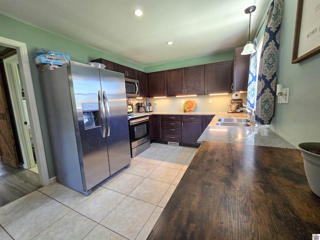 2230 Seneca Ln, Paducah, KY 42001 - kitchen with stainless steel appliances, a sink, light tile patterned floors, dark brown cabinetry, and recessed lighting