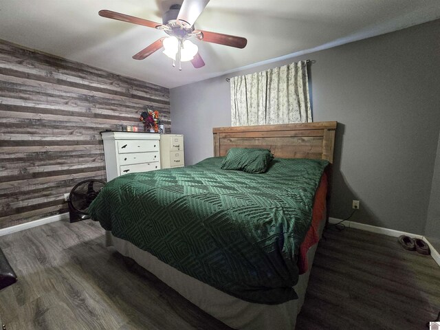 2230 Seneca Ln, Paducah, KY 42001 - bedroom with baseboards, wooden walls, wood finished floors, a ceiling fan, and an accent wall