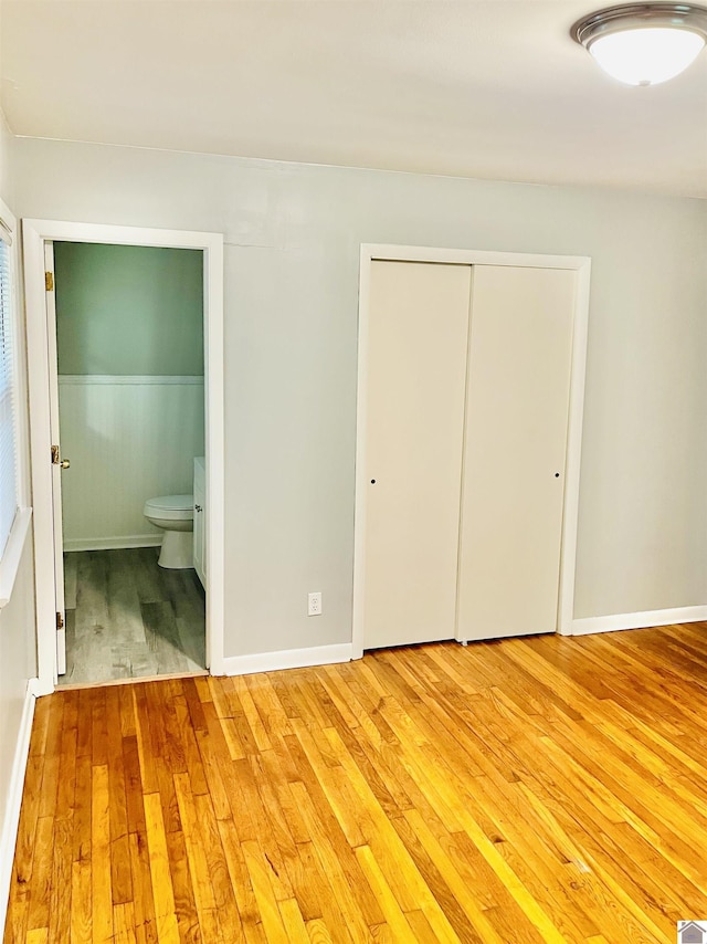 908 N 21st St, Paducah, KY 42001 - unfurnished bedroom with hardwood / wood-style floors, a closet, ensuite bath, and a wainscoted wall