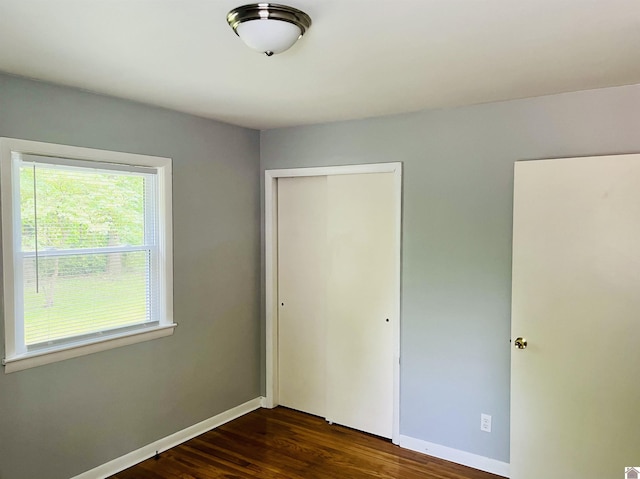 908 N 21st St, Paducah, KY 42001 - unfurnished bedroom featuring a closet, dark wood-style flooring, and baseboards