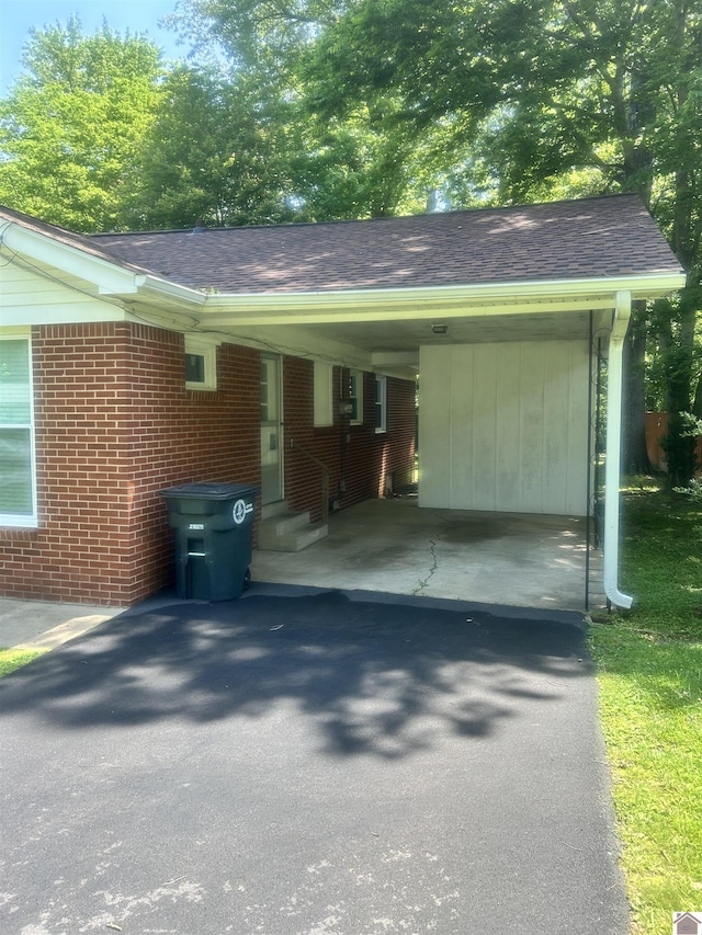 908 N 21st St, Paducah, KY 42001 - view of property exterior with asphalt driveway, entry steps, an attached carport, brick siding, and roof with shingles