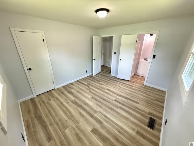 701 N 18th St, Murray, KY 42071 - unfurnished bedroom featuring light wood-type flooring, baseboards, and ensuite bath