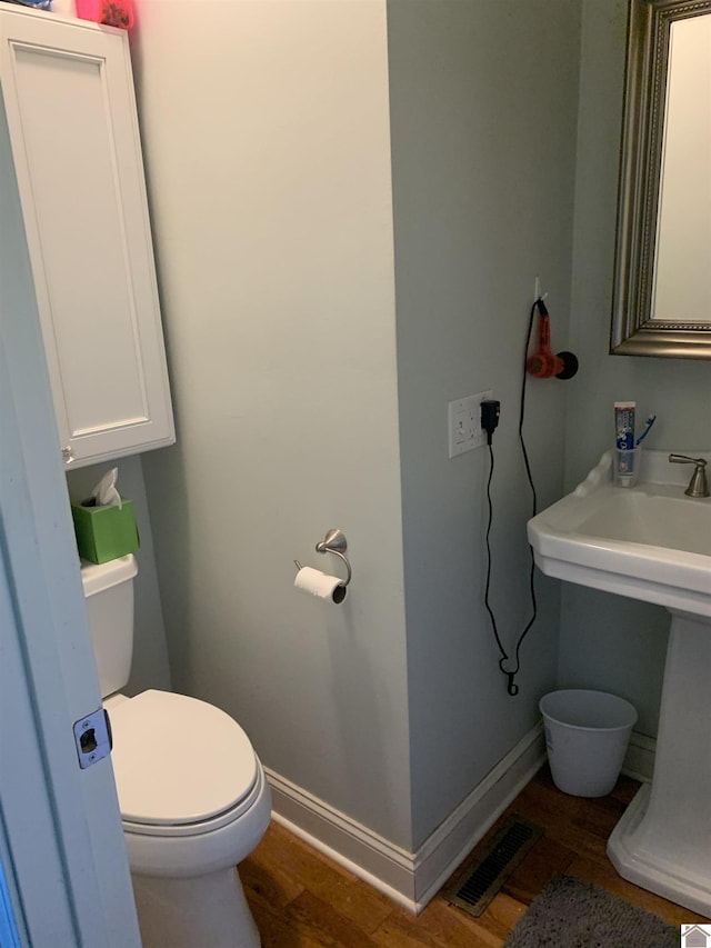 10187 E U S Highway 68, Benton, KY 42025 - half bathroom featuring wood finished floors, toilet, baseboards, and a sink