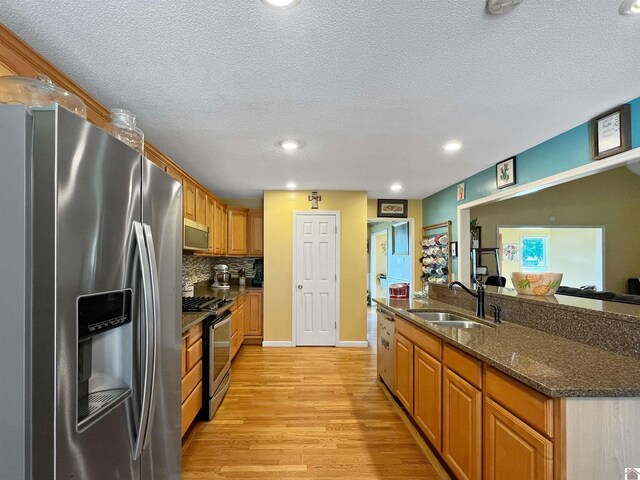189 Edinborough W, Murray, KY 42071 - kitchen with appliances with stainless steel finishes, a sink, light wood-type flooring, a textured ceiling, and tasteful backsplash