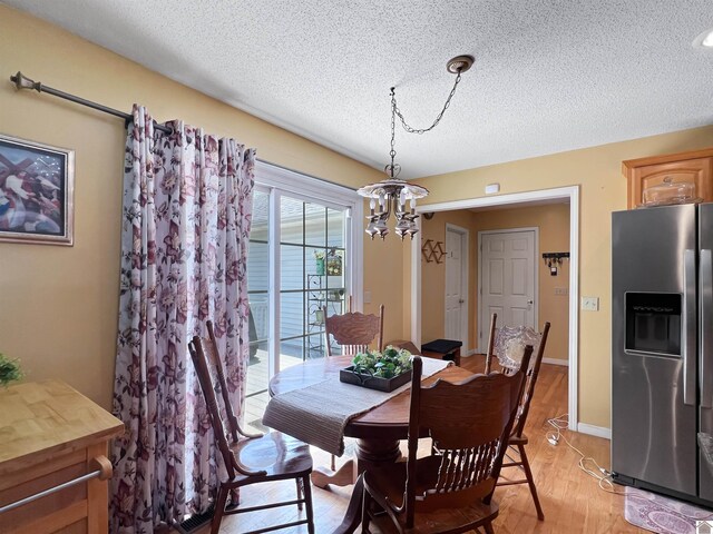 189 Edinborough W, Murray, KY 42071 - dining room featuring a textured ceiling, light wood-type flooring, a chandelier, and baseboards