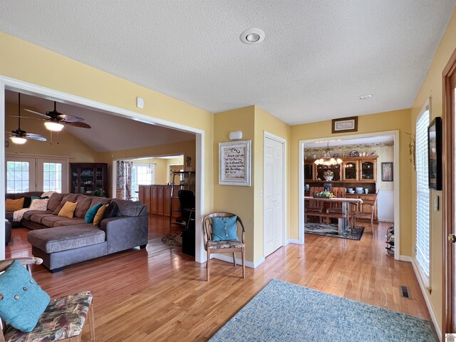 189 Edinborough W, Murray, KY 42071 - living area featuring a textured ceiling, light wood-style floors, a chandelier, a ceiling fan, and baseboards