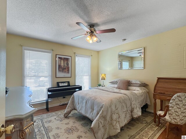 189 Edinborough W, Murray, KY 42071 - bedroom featuring wood finished floors, a textured ceiling, baseboards, and ceiling fan