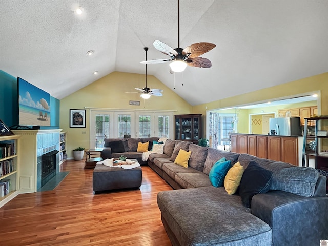 189 Edinborough W, Murray, KY 42071 - living area featuring a ceiling fan, a fireplace with flush hearth, light wood-style flooring, high vaulted ceiling, and a textured ceiling