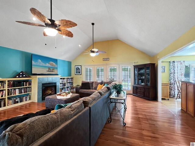189 Edinborough W, Murray, KY 42071 - living room featuring ceiling fan, wood finished floors, a tiled fireplace, healthy amount of natural light, and high vaulted ceiling