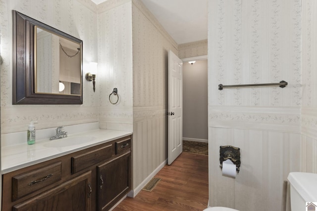 1158 State Route 295, Marion, KY 42064 - half bathroom featuring toilet, wood finished floors, wallpapered walls, vanity, and wainscoting