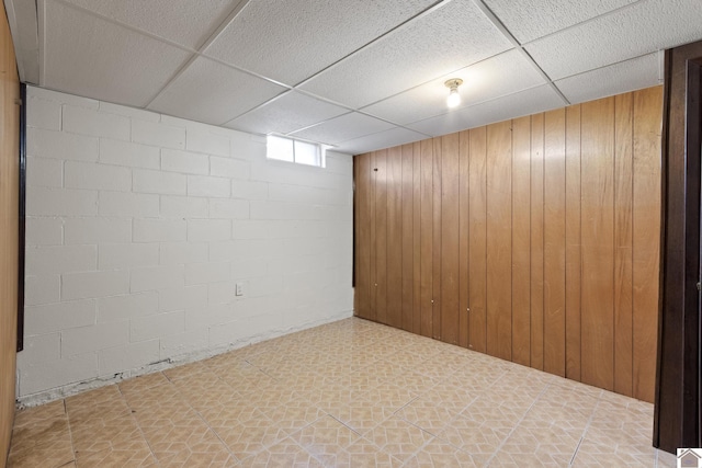1158 State Route 295, Marion, KY 42064 - basement featuring a paneled ceiling, tile patterned floors, wood walls, and concrete block wall