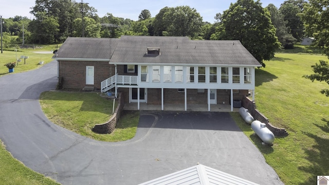 1158 State Route 295, Marion, KY 42064 - view of property with asphalt driveway, a front lawn, brick siding, and roof with shingles