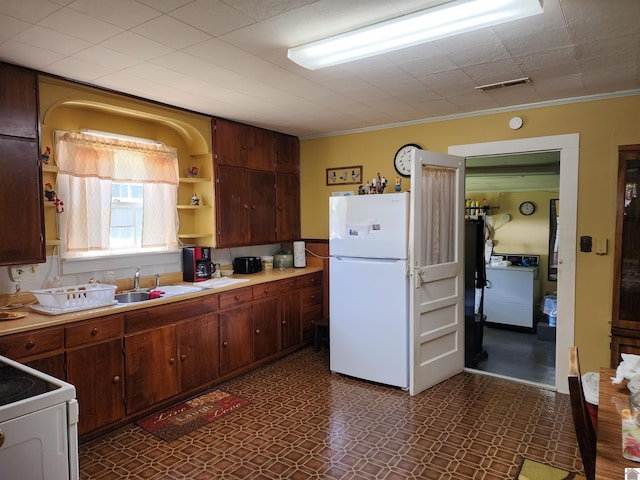 1691 Symsonia Hwy, Benton, KY 42025 - kitchen featuring freestanding refrigerator, a sink, washer / clothes dryer, dark floors, and open shelves