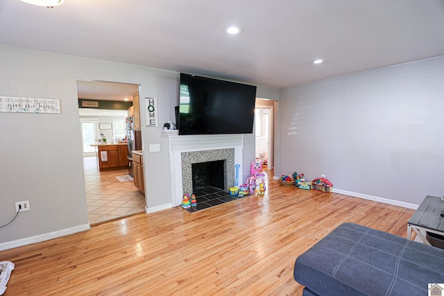 157 Calvert Dr, Paducah, KY 42003 - unfurnished living room with a tiled fireplace, light wood finished floors, recessed lighting, and baseboards