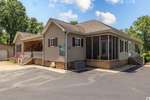 124 Hughes Rd, Benton, KY 42025 - view of front facade with an outbuilding, crawl space, a sunroom, a shingled roof, and a ceiling fan