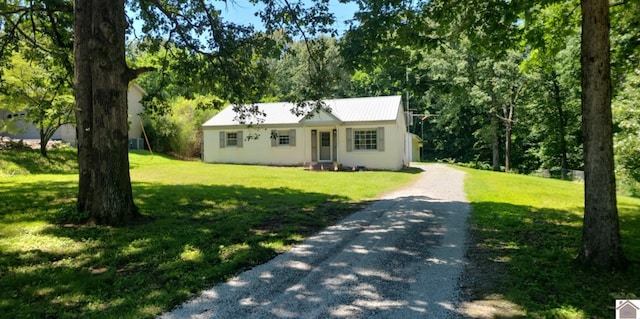 135 Phipps St, Paducah, KY 42001 - view of front facade with gravel driveway, a front lawn, stucco siding, and metal roof