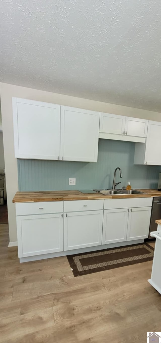 135 Phipps St, Paducah, KY 42001 - kitchen featuring wooden counters, a sink, light wood-style floors, white cabinets, and a textured ceiling