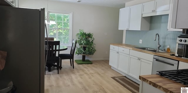 135 Phipps St, Paducah, KY 42001 - kitchen featuring stainless steel appliances, a sink, butcher block countertops, light wood finished floors, and white cabinets